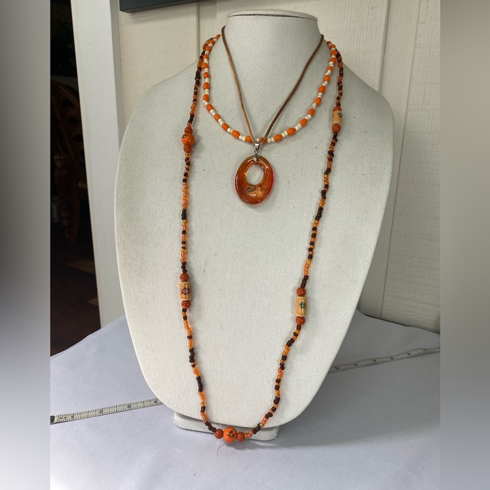 Three orange color bead and medallion necklaces